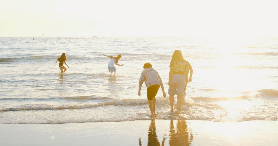 Family playing at the beach on hot summers day
