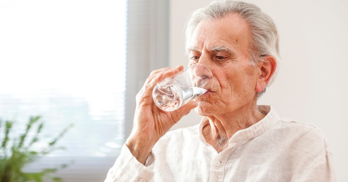 Elder man drinking water to stay hydrated
