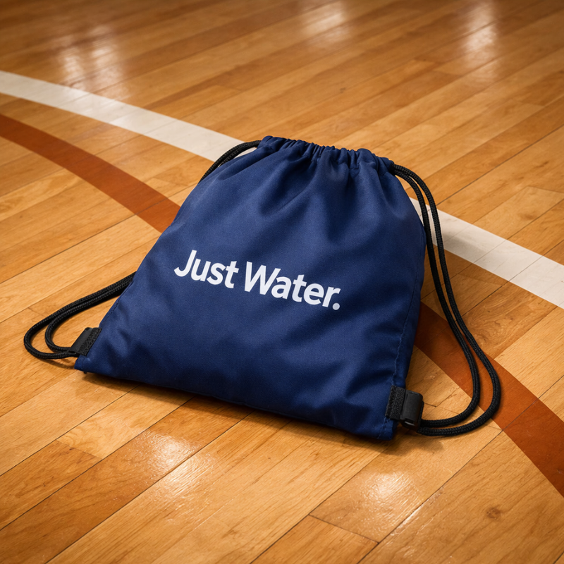 Drawstring backpack displayed on gym floor used for sports activities 