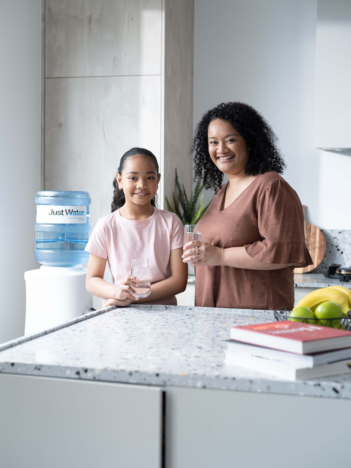 Mother and daughter drinking Just Water in the home kitchen